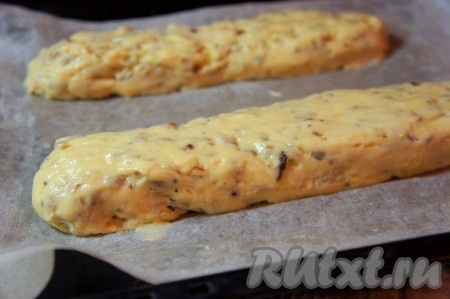 Духовку разогреть до 180 градусов. Противень застелить бумагой для выпечки, смазать её растительным маслом с помощью кондитерской кисти. Влажными руками разделить тесто на 2 части, из каждой части сформировать "колбаску" и выложить "колбаски" на противень, придав им окончательную форму.