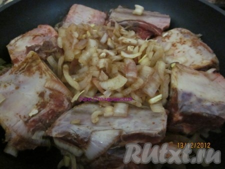 Сверху выкладываем замаринованные ребрышки, слегка обжариваем и добавляем нарезанный полукольцами лук. Готовим на сковороде под крышкой 30 минут.
