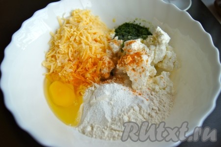 Растопить в микроволновой печи (или на плите) сливочное масло, остудить, а затем вместе с яйцом, солью, специями и мелко нарезанной зеленью отправить в миску к остальным ингредиентам, тщательно перемешать. Должна получиться густая творожно-сырная масса.
