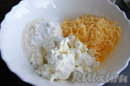В глубокой миске соединить творог, муку с разрыхлителем, натёртый сыр.
