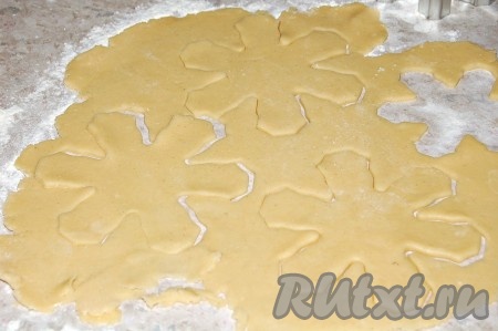 Достать тесто через час, раскатать его в пласт и вырезать формочкой снежинки.