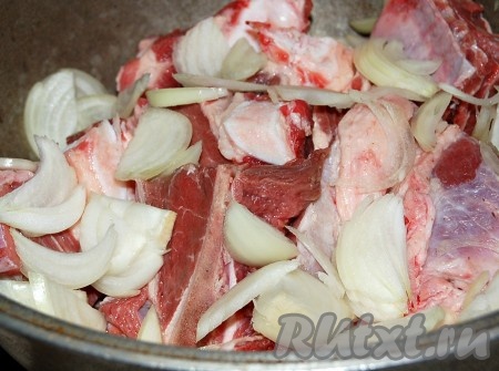 Уложить грудинку в казан, сверху уложить слой тонко нарезанного репчатого лука.
