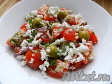 Смешать все составляющие салата (кускус, помидоры, лук, петрушку), добавить оливки, посолить, поперчить, заправить оливковым маслом и лимонным соком. Сыр Фета раскрошить и добавить в блюдо.
