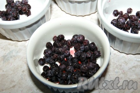 На дно формочек положить чернику.