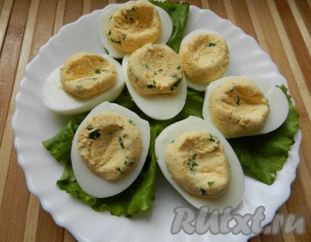 Так как предполагается сверху начинки уложить икру, сделать в желтках небольшие углубления с помощью чайной ложки и заполнить их икрой лосося.
