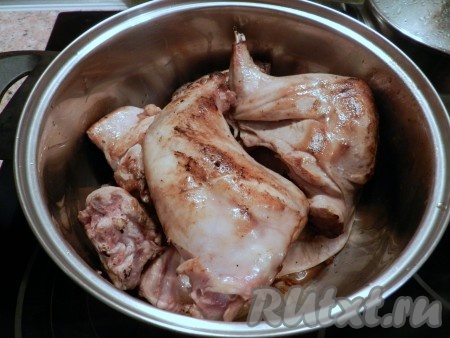 На дно кастрюли выложить лук, сверху обжаренные кусочки кролика, долить немного воды, довести до кипения, уменьшить огонь и тушить 30 минут.