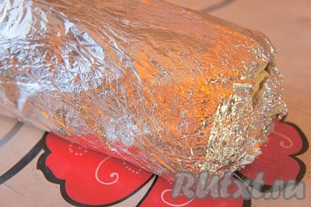 Завернуть рулет из лаваша с ветчиной плотно в фольгу, дать пропитаться около 15-20 минут при комнатной температуре, а затем убрать его охлаждаться на 20-30 минут.
