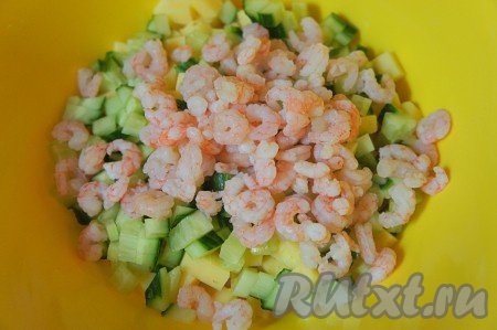 Вскипятить в кастрюле воду, затем выложить замороженные креветки и после закипания воды варить на небольшом огне 2-3 минуты. Варёные креветки откинуть на сито, дать остыть, почистить. Добавить очищенные креветки в наш салат "Коктейль".