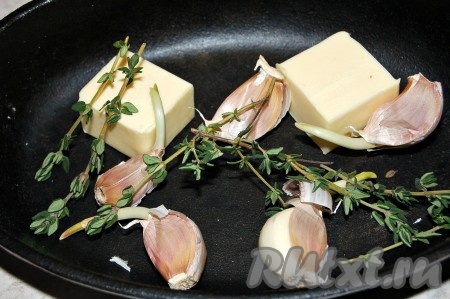 На сковороду выложить кусочки холодного сливочного масла, нечищеные зубчики чеснока и веточки свежего тимьяна.