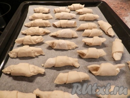 Противень застелить бумагой, выложить на него рогалики.