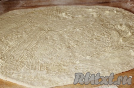 Тесто делим на 2 части. Каждую часть раскатываем в пласт и смазываем растопленным сливочным маслом.