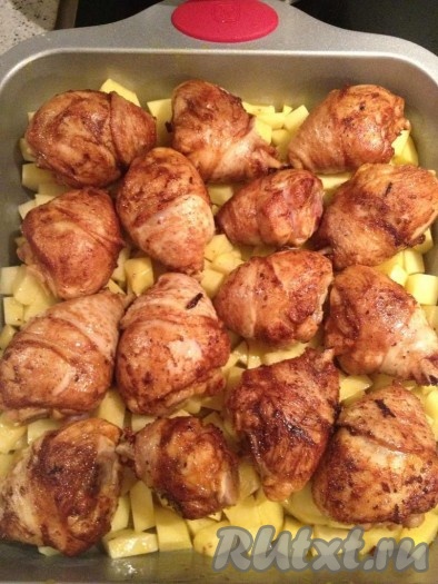 Когда куриные бедра пропитались маринадом, обжариваем их на большом огне по 2 минуты с каждой стороны и кладем к картошке. Сверху выливаем остатки заправки для курицы и отправляем в разогретую до 200 градусов духовку на 45 минут.&nbsp;
