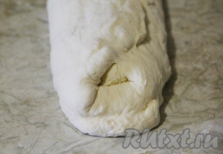 Отдохнувшее тесто начинаем формировать в багеты. Замешивать тесто особо не нужно. Раскатываем его в пласт и подворачиваем края к центру.
