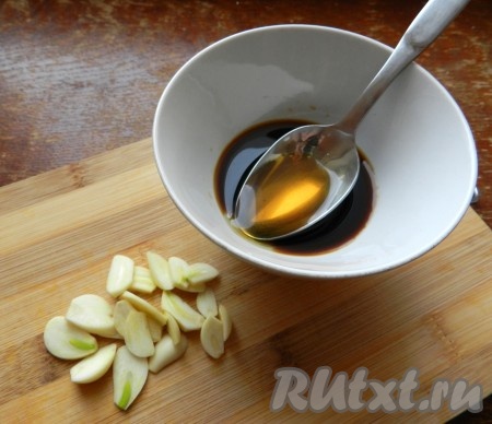 Чеснок очистить и нарезать на тонкие пластинки. В небольшой ёмкости соединить мёд и соевый соус, перемешать получившийся соево-медовый соус.