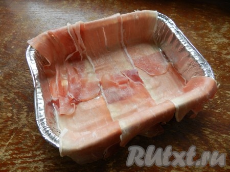Форму для запекания выстлать ломтиками копчёного бекона так, чтобы концы свисали.
