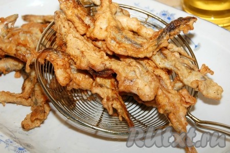 Выкладывать на блюдо. И так пережарить всю мойву небольшими партиями.