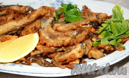 Добавить к готовой мойве в кляре дольку лимона и несколько веточек петрушки.