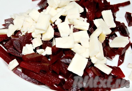 Сыр нарезать на небольшие кубики и выложить к свекле.