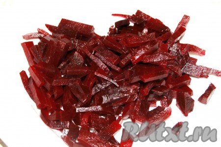 Свеклу тщательно вымыть, выложить в небольшую кастрюльку, полностью залить водой, отправить на огонь и варить до готовности (45-60 минут с начала кипения воды). Готовый овощ будет легко прокалываться ножом. Остудить варёную свеклу, очистить и нарезать небольшими кусочками (можно натереть на крупной тёрке), выложить в салатник.