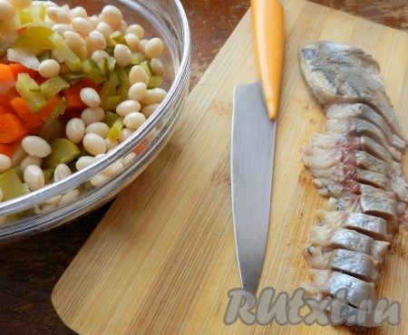 Добавить в винегрет отваренную фасоль. Филе сельди очистить от кожи и костей и нарезать тонкими полосками.