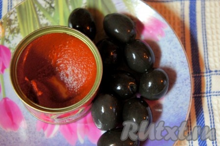 Добавить томатную пасту, маслины, отварную красную рыбу, перемешать, готовить ещё 5 минут, затем выключить огонь, накрыть солянку крышкой и дать ей настояться не менее 15 минут.
