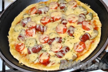 Посыпаем тертым сыром и ароматными травами, накрываем сковороду крышкой и продолжаем готовить, пока сыр не расплавится. Через 7-10 минут, когда сыр расплавится, быстрая пицца - готова!