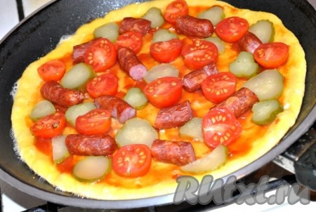 Сверху выкладываем начинку: колбаски, помидоры и огурцы.
