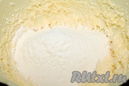 В отдельную миску просеять муку. Всыпать в тесто весь разрыхлитель. Затем добавить только 1/3 часть просеянной муки и перемешать тесто миксером на низких оборотах.