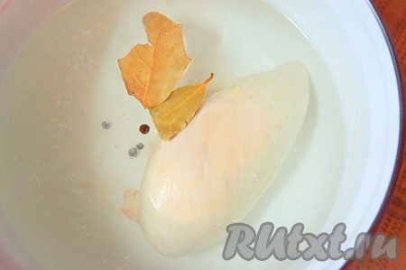 Куриную грудку промыть, залить 2 литрами холодной воды, добавить лавровый лист, перец горошком и поставить на средний огонь. Готовить 10 минут, периодически снимая накипь.