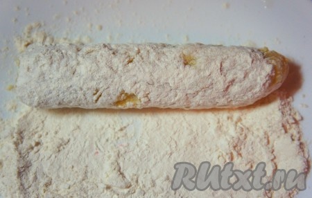 Влажными руками взять немного картофельного теста, распределить по руке, положить сосиску и распределить картофельное тесто так, чтобы оно закрыло сосиску со всех сторон. Запанировать полученную "палочку" в муке. Аналогично повторить для остальных "палочек".&nbsp;
