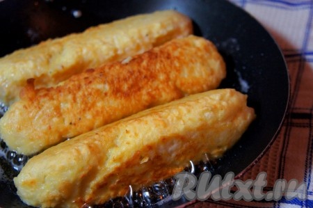 Растительное масло разогреть, добавить к нему крупно нарезанный чеснок и прокалить. Следить, чтобы чеснок не подгорел. Чеснок убрать из масла. На чесночном масле обжарить сосиску в картошке до устойчивой золотистой корочки.
