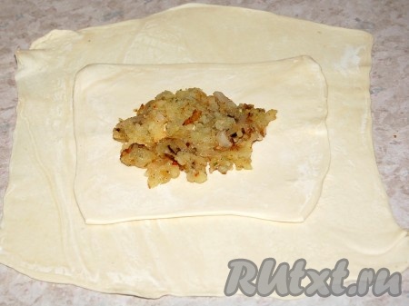 Слоеное тесто раскатать на два квадрата разных размеров: один побольше, другой поменьше. На квадрат большего размера уложить квадрат меньшего размера и в центр второго квадрата выложить гарнир из картофеля с луком.