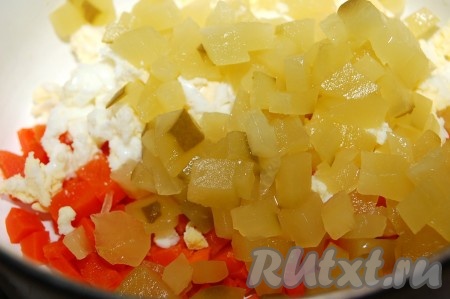 Маринованные огурцы нарезать мелким кубиком и добавить к салату.