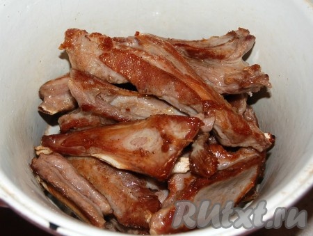 Обжаренные бараньи ребрышки сложить в латку для тушения.