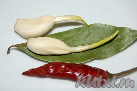 Добавить лавровый лист и чеснок целыми дольками. Острый сушеный перец тоже добавить целиком и следить внимательно, чтобы он не поломался, иначе блюдо будет чересчур острым и горьким. По окончании тушения бараньих ребрышек лавровый лист и острый перец выкинуть.
