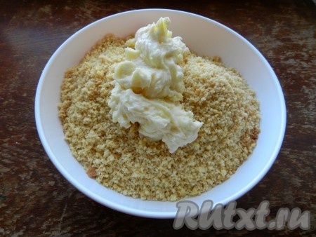 Смешать бисквитные крошки с кремом в однородную массу.