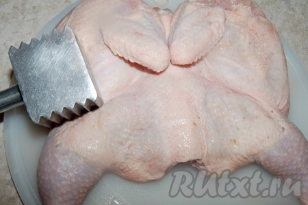 Для приготовления чкмерули лучше брать молодую курочку или цыплёнка. Курицу промыть водой, разрезать по грудине, но не до конца, чтобы можно было распластать тушку, как книжку. Срезать гузку и лишний жир. Распластать вдоль хребта. С помощью кулинарного молоточка аккуратно отбить, чтобы курочка приняла более плоскую форму.