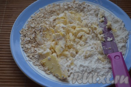 В это время сделать посыпку: холодное сливочное масло, муку и овсяные хлопья растереть в крошку. Это можно сделать ножом или руками.