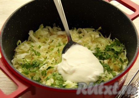 Разогреть в кастрюле с толстым дном (или в сковороде) 1 столовую ложку растительного масла, обжарить лук до золотистого цвета (ориентировочно в течение 3-4 минут) на среднем огне, иногда помешивая. Добавить капусту, готовить на огне выше среднего минут 5, чтобы капуста "обмякла". Затем жарить капусту на огне ниже среднего под крышкой минут 15, иногда перемешивая. После этого добавить зелень и сметану, приправить солью и перцем. Перемешать и тушить на среднем огне минут 5-7 (до мягкости капусты), время от времени помешивая.