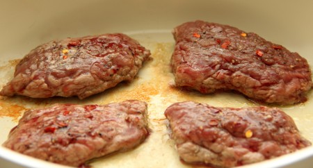 На отдельной сковороде на растительном масле обжарить отбивные из телятины на среднем огне до румяной корочки с двух сторон (минут по 6 минут с каждой стороны).