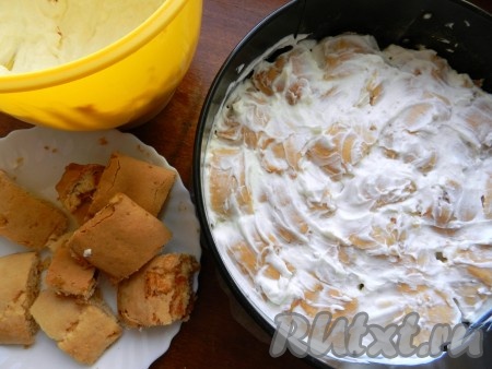 Разъёмную форму для выпечки (или другую) застелить бумагой. Каждый кусочек рулета макать в сметанный крем и плотно укладывать в форму в произвольном порядке. Таким образом сделать два слоя.
