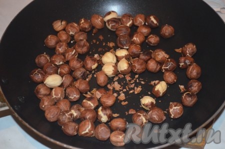 Сливочное масло достать из холодильника, чтобы оно согрелось и стало достаточно мягким. Орехи обжарить на сухой сковороде, помешивая, в течение 5-7 минут. Дать орехам немного остыть, очистить от шелухи.