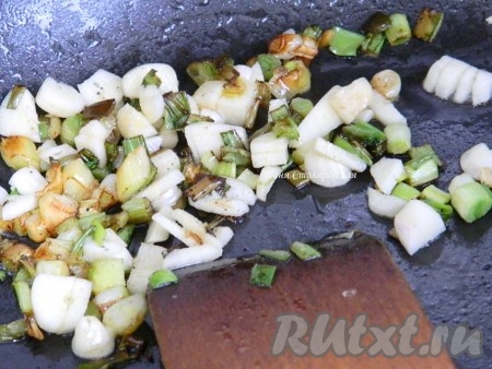 Нагреваем в сковороде сливочное масло, высыпаем зеленый лук и слегка обжариваем. Добавляем порезанный чеснок.
