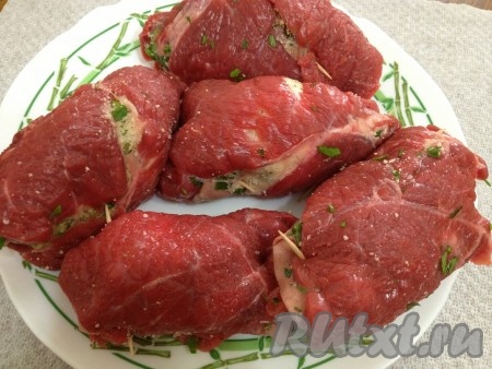 Закрутить мясо рулетиками и закрепить их зубочистками.
