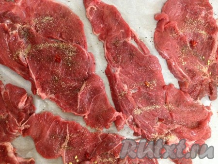 Мясо посолить и поперчить. Посыпать мелко нарезанным чесноком и перцем чили.
