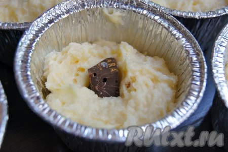Формочки смазала маслом, разложила творожную массу по формочкам до половины, в центр положила по кусочку шоколада.
