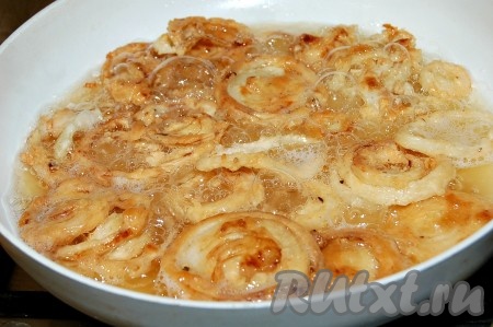 Жарить кольца лука на среднем огне. Как только лук зарумянится с одной стороны, сразу перевернуть кольца и жарить до подрумянивания с другой стороны (примерно 5-7 минут).