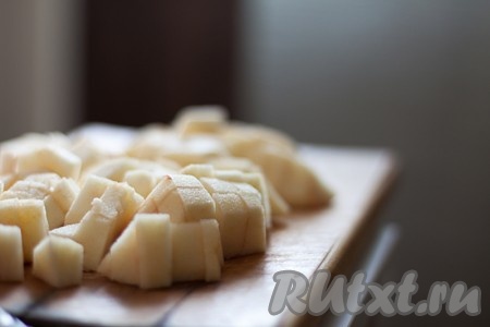 Соедините размягченное масло с мукой в крошку, добавьте желток, воду и быстро замесите эластичное тесто. Скатайте его в шар, заверните в пищевую пленку и уберите в холодильник на 40 минут. Тем временем очистите от кожицы яблоки и нарежьте кубиками.
