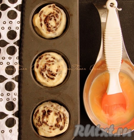 Смажьте булочки взбитым с молоком яйцом.