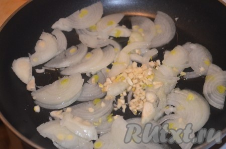 На среднем огне обжарить на оливковом масле лук полукольцами и измельченный чеснок.